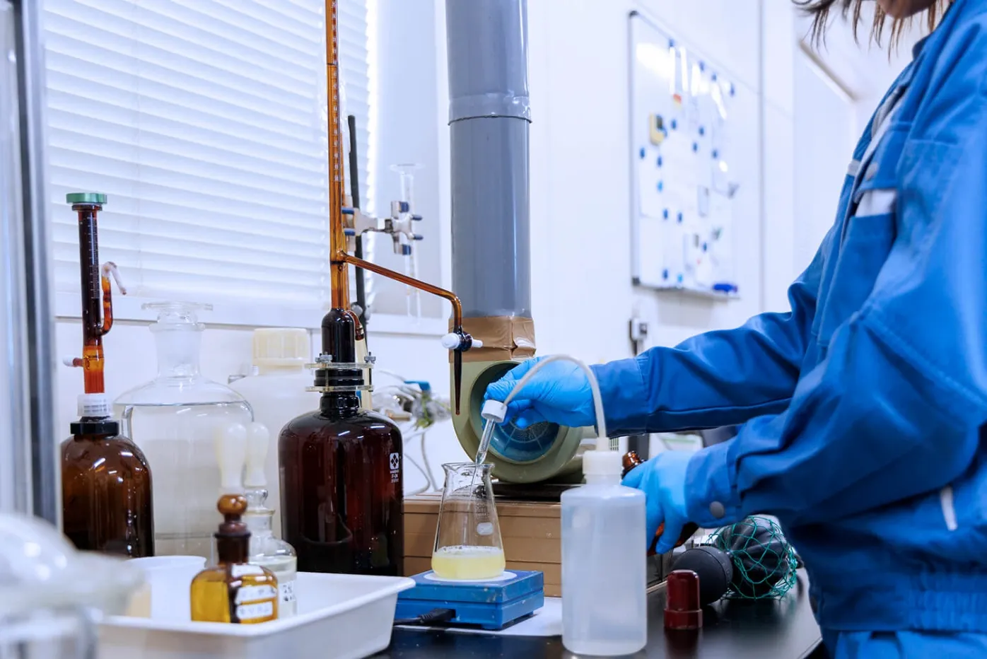 実験室でビーカーに液体を加える作業の様子