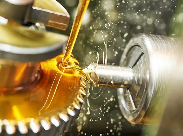 歯車に潤滑油を注ぐ機械加工の様子