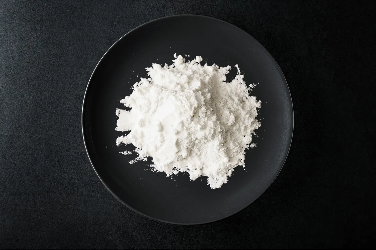 黒い皿に盛られた白色の粉末状の製品