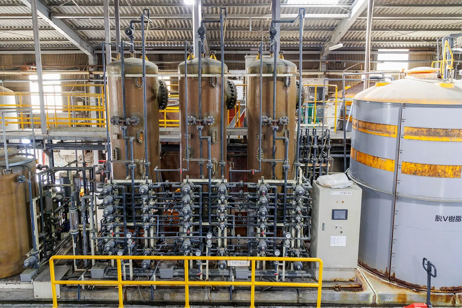 工場内の大型タンクと配管設備