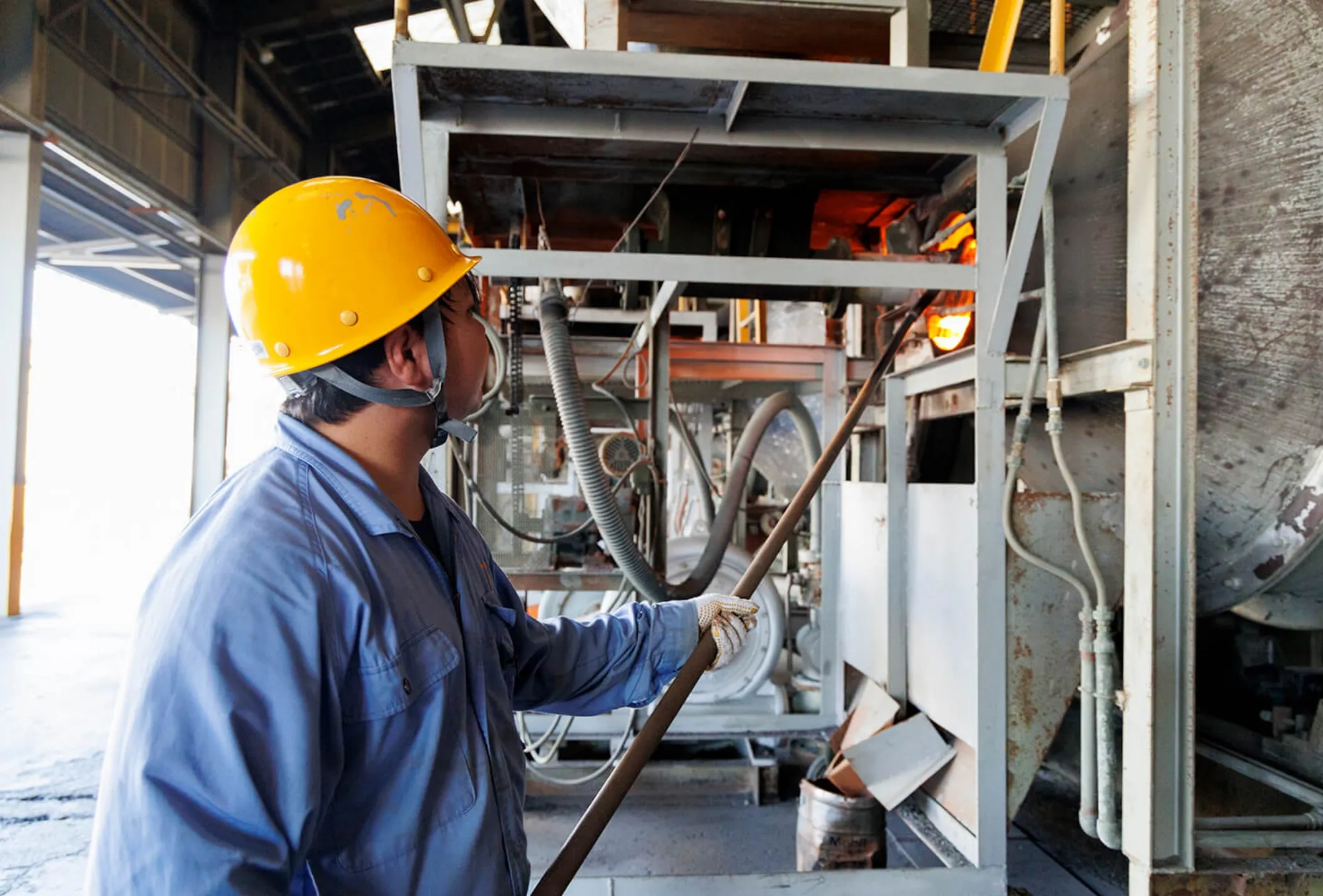 工場内で炉の操作作業を行う男性社員