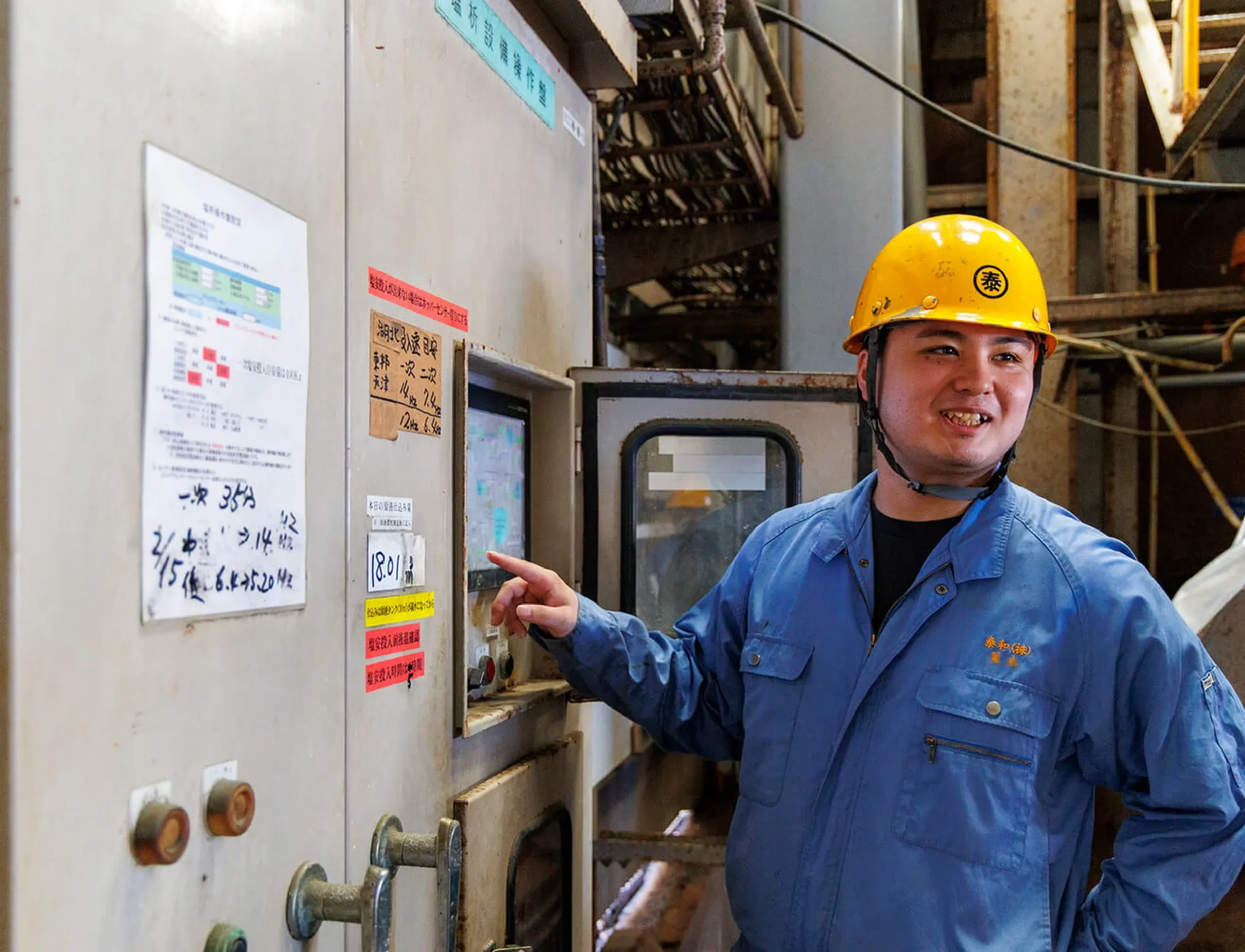 工場内で制御盤の操作を行う男性社員