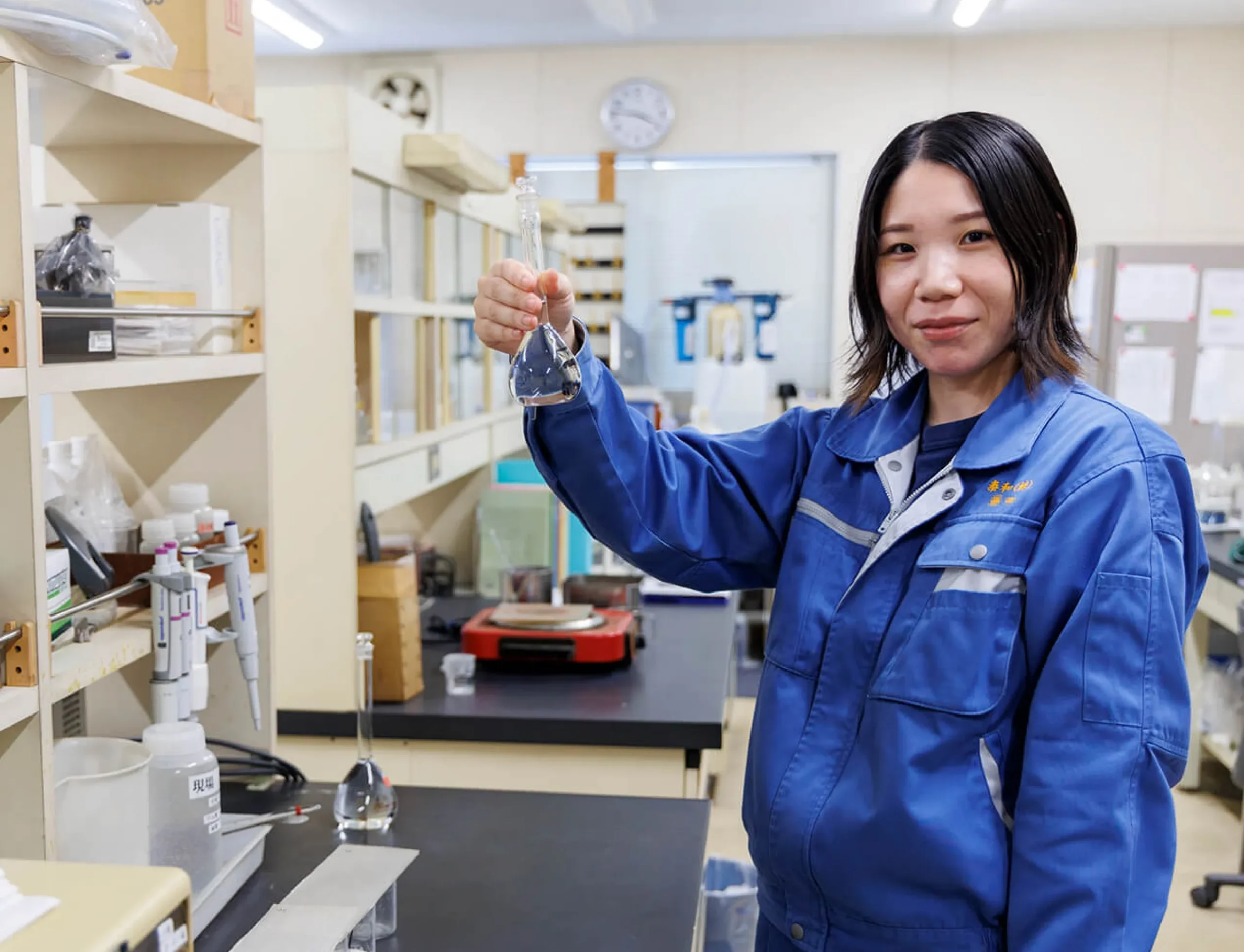 フラスコを持つ作業着の社員